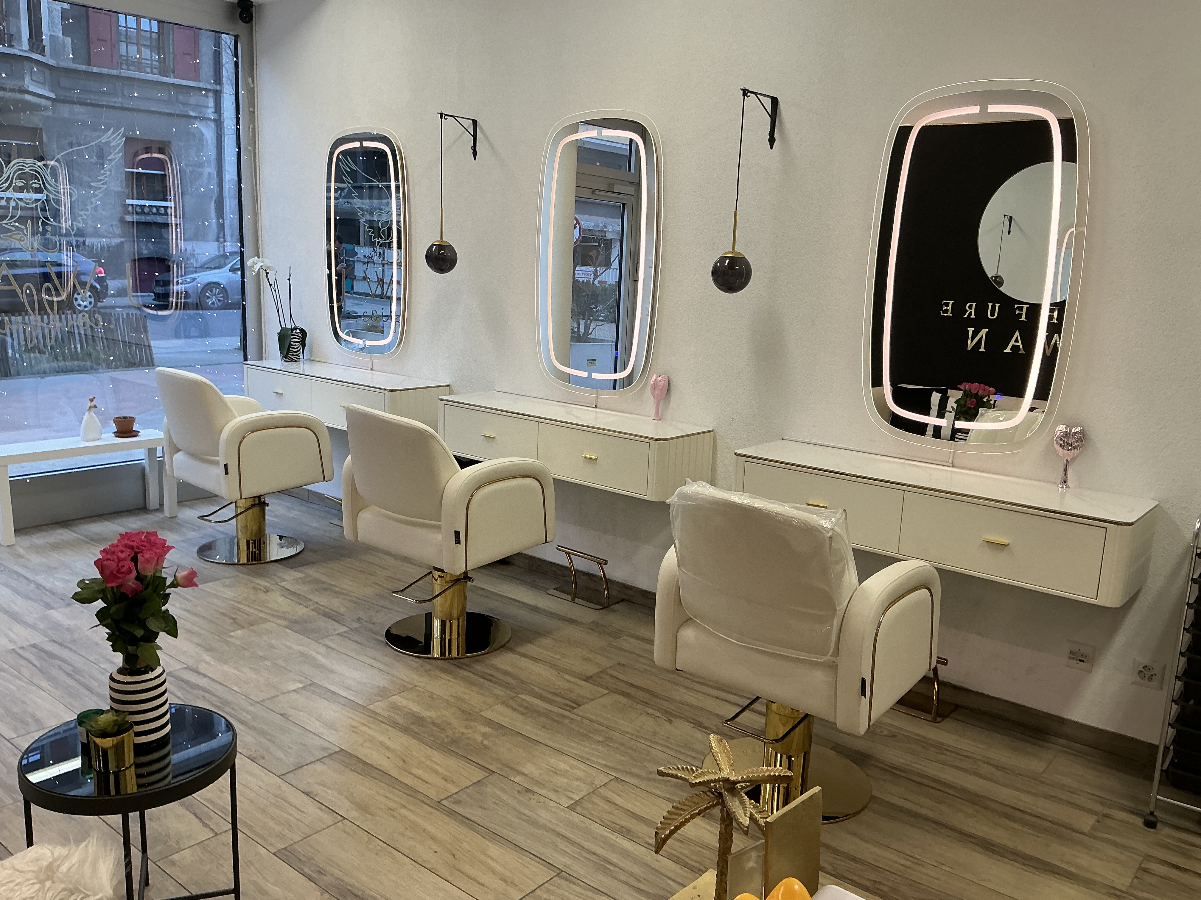 Salon de coiffure à Genève, fauteuils clairs et miroirs lumineux